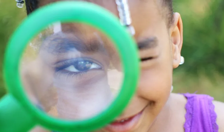 girl camper with magnifying glass
