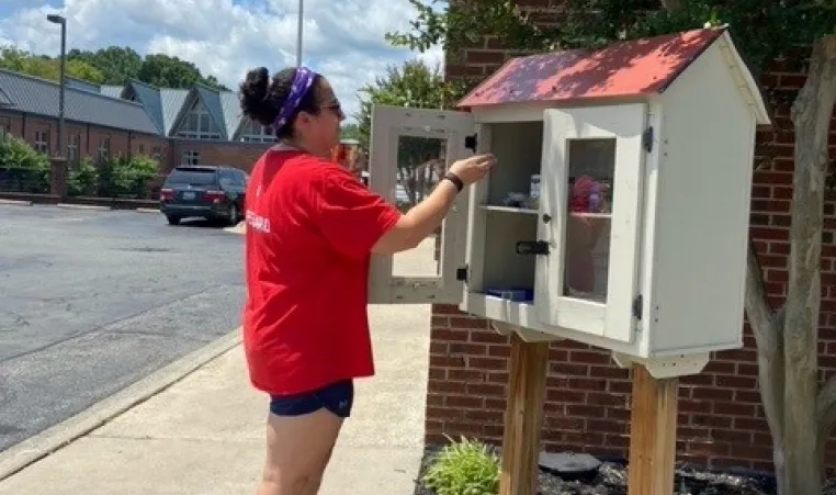staff person adding nonperishable food to Blessings Box