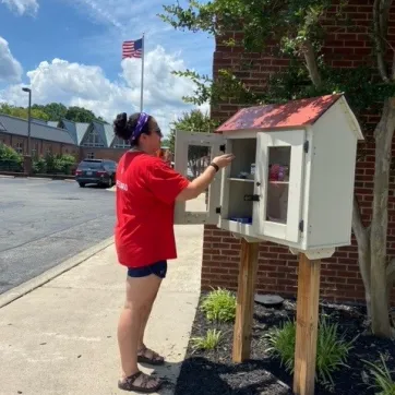 staff person adding nonperishable food to Blessings Box