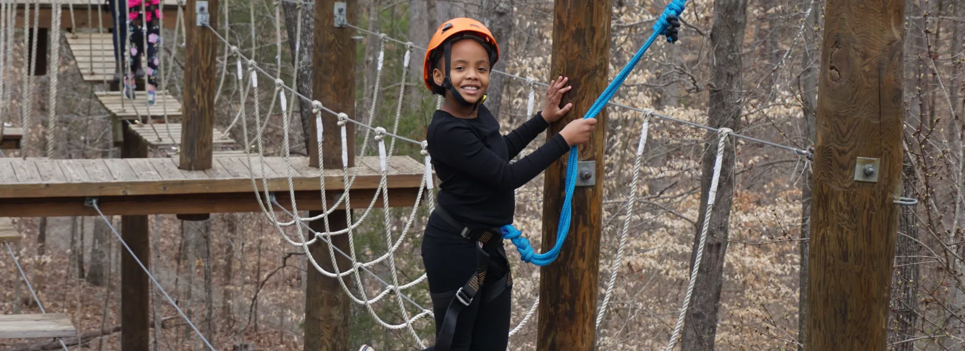child enjoying high ropes course at Camp Weaver in Greensboro